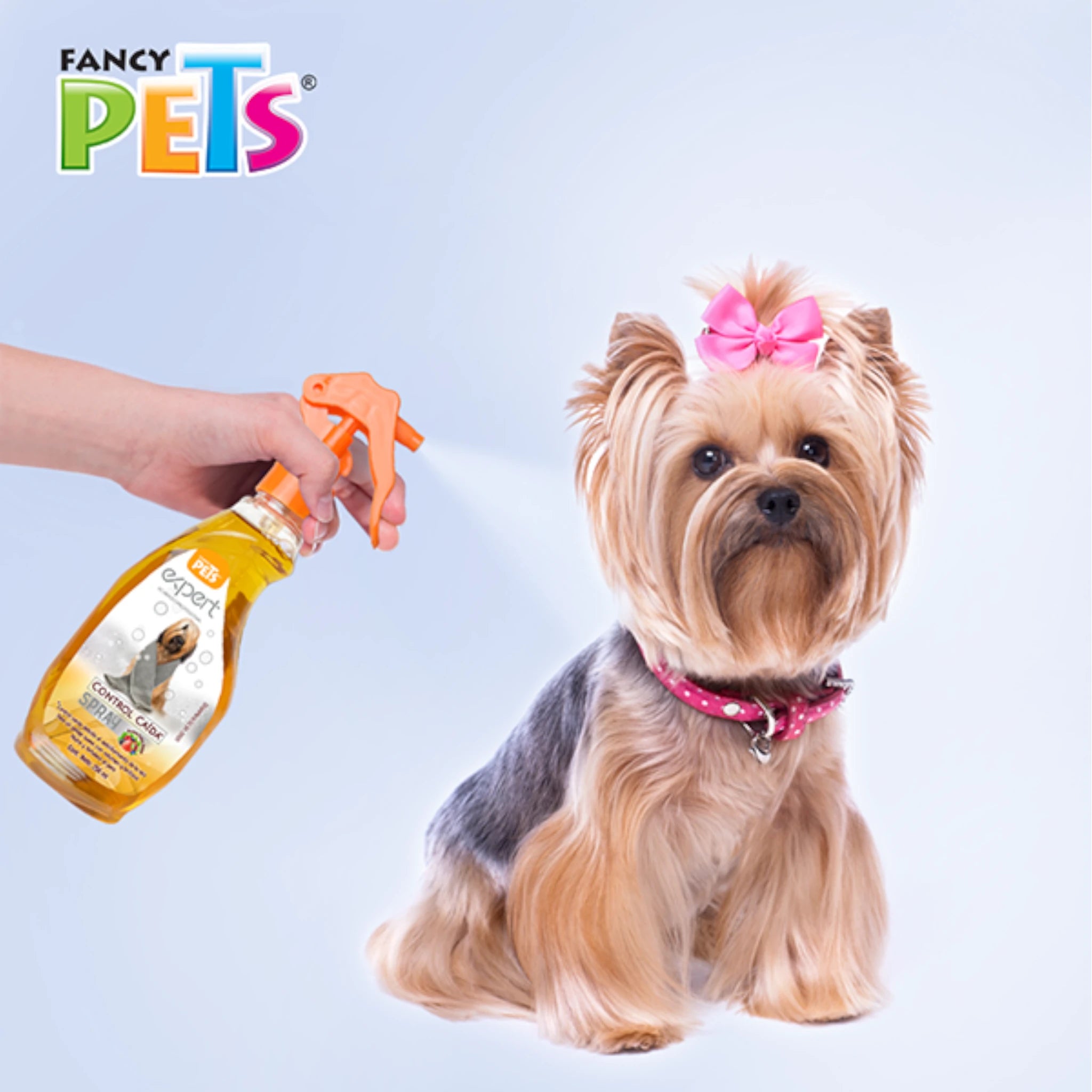 Perro pequeño con moño rosa siendo rociado con el Spray Control Caída Fancy Pets