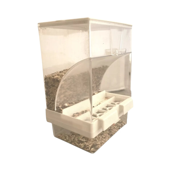 Comedero tipo tolva transparente  lleno de semillas para aves pequeñas