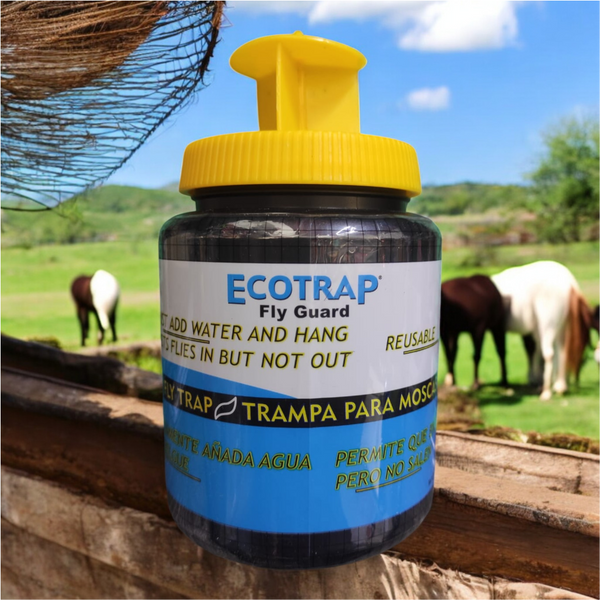 Trampa Ecotrap colgada en un establo con caballos al fondo, diseñada para atraer y retener moscas mediante cebo activado con agua.